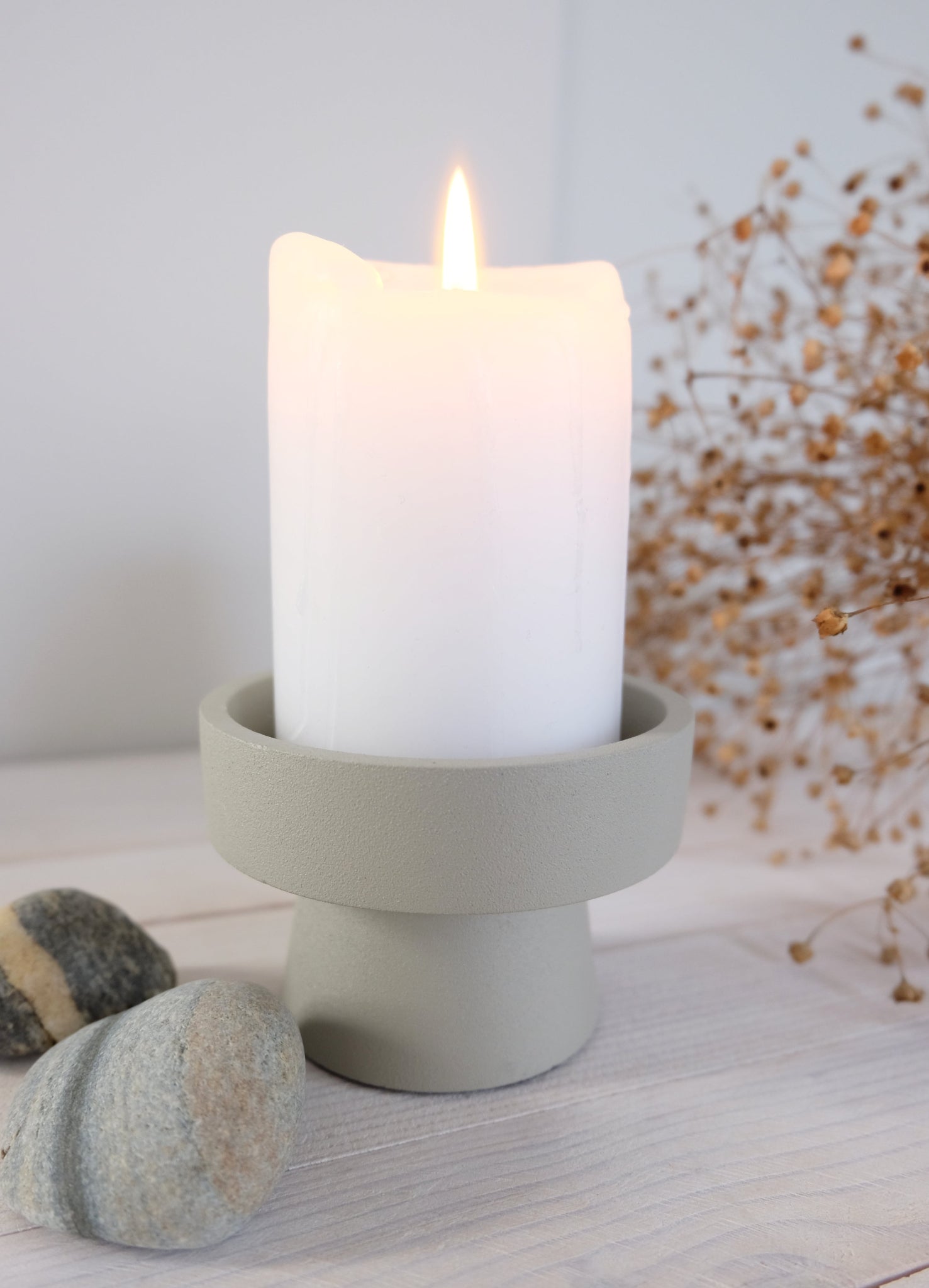 Kynttilänjalka Anker pöytäkynttilällä – hiekanvärinen metallikynttilänjalka käytössä