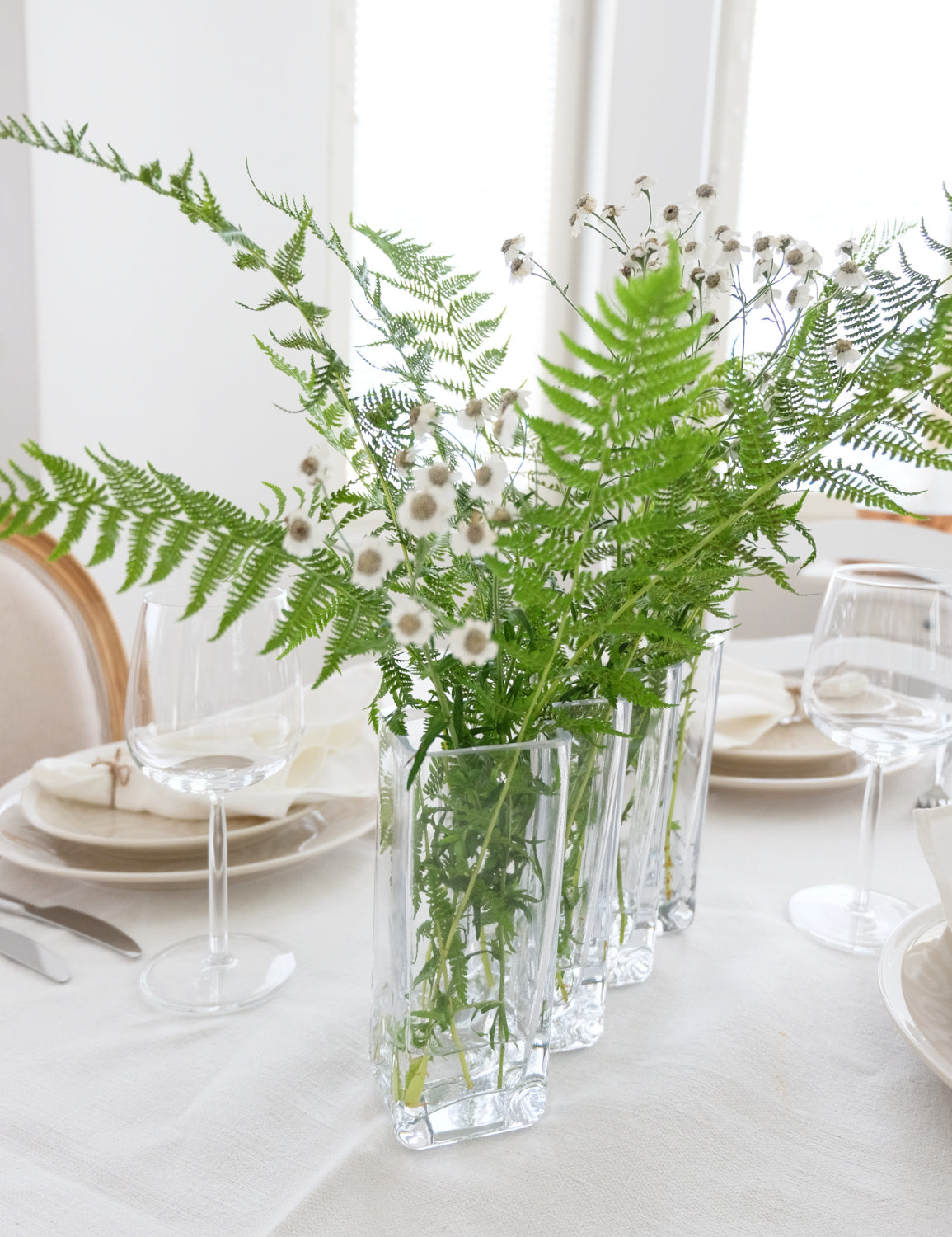 Maljakko Row kukilla – kirkas suupuhallettu lasimaljakko kukka-asetelma katettu pöytä