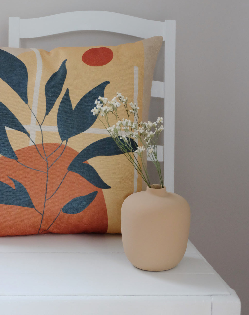 Alise-tyyny tuolilla – beige oranssi kuviollinen sisututyynynpäällinen olohuoneessa