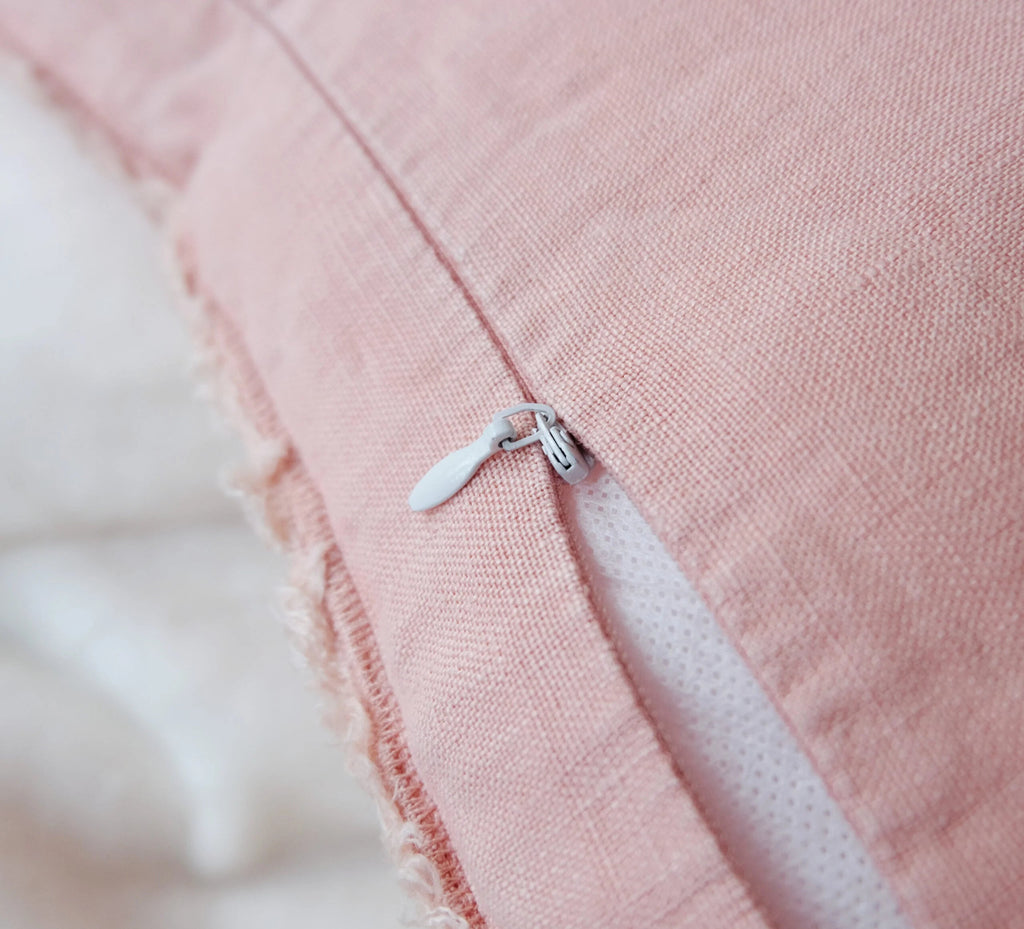 Lähikuva Peach Pink -tyynyn vetoketjusta – pellavainen reunahapsu detalji