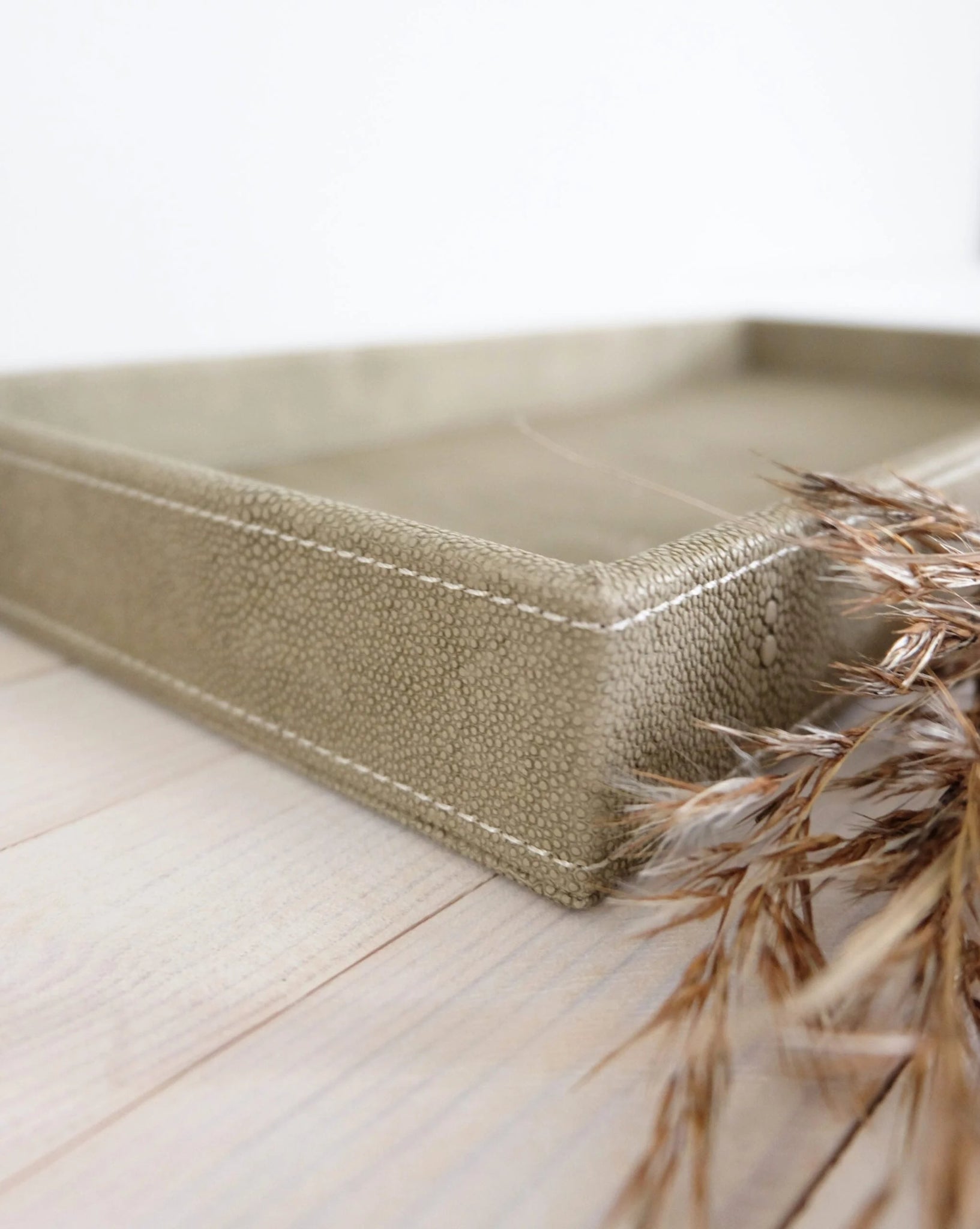 Lähikuva Sting-tarjottimen hiekanvärisestä keinonahkapinnasta