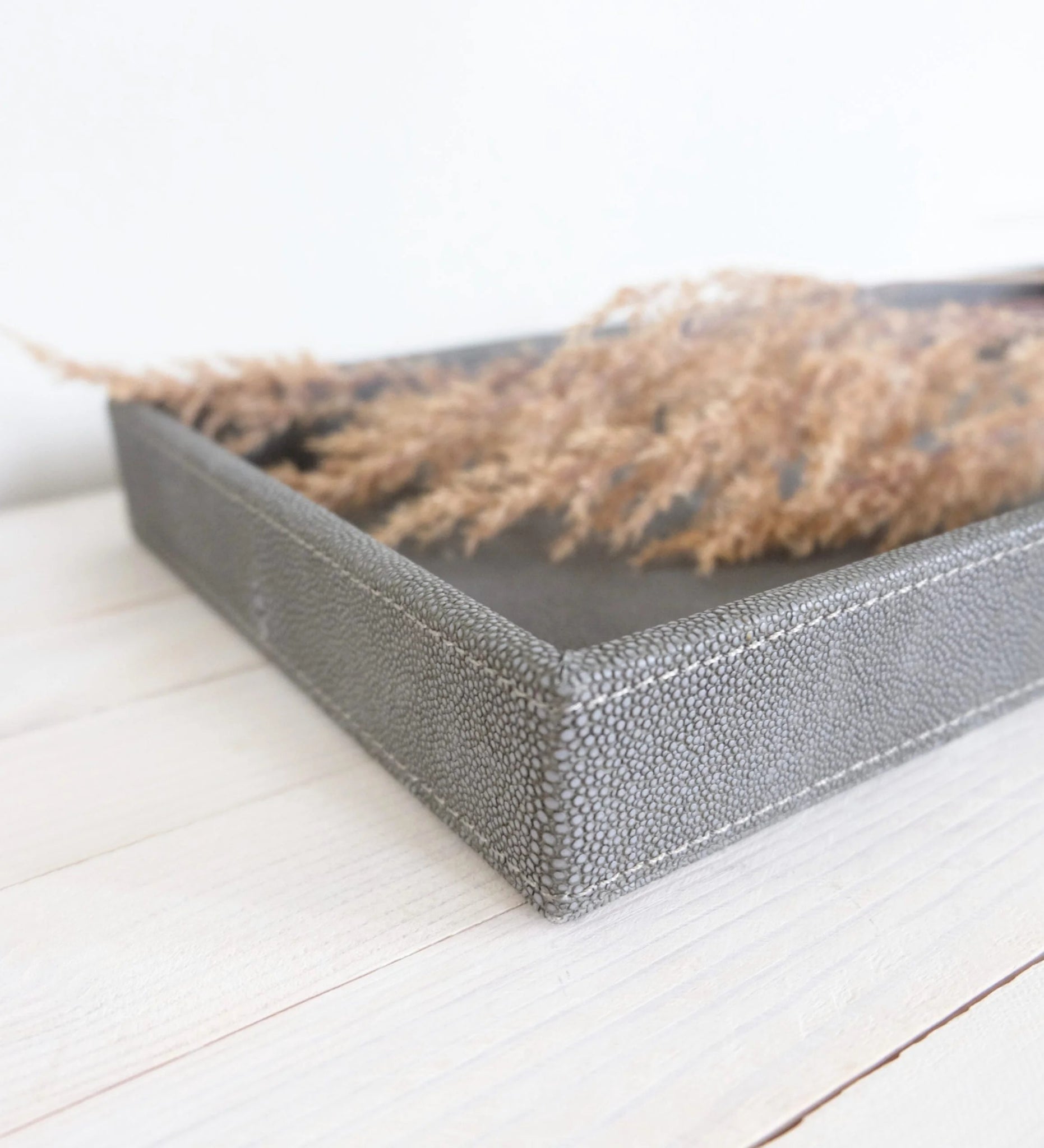 Lähikuva Sting-tarjottimen antrasiitinvärisestä keinonahkapinnasta