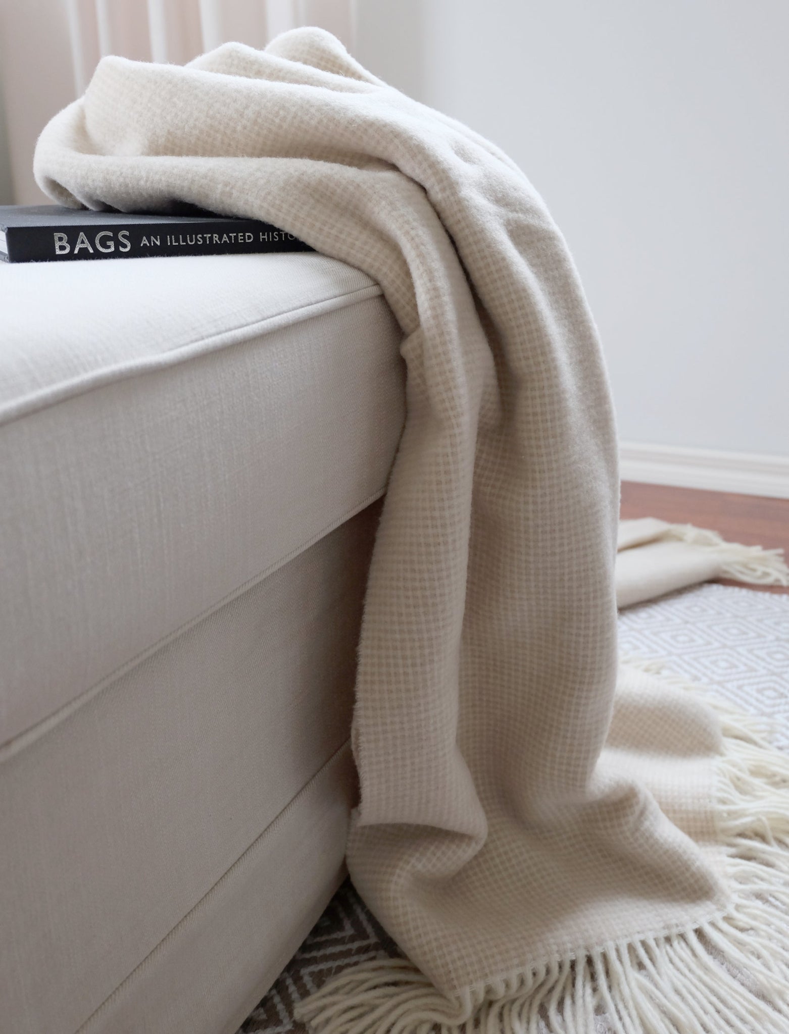 Torkkupeitto Portofino sohvalla – luonnonvalkoinen merinovilla sisustusdetalji olohuone