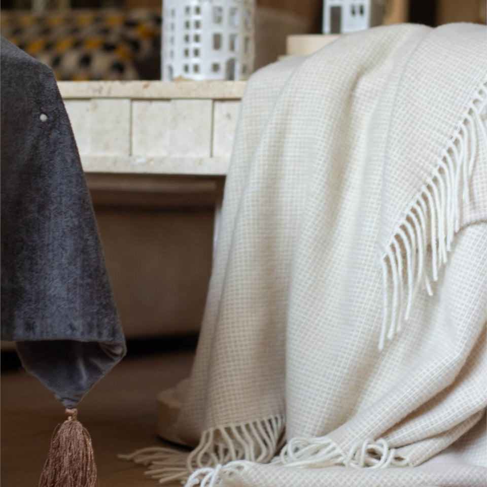 Torkkupeitto Portofino olohuoneessa – luonnonvalkoinen merinovillainen peitto sisustus