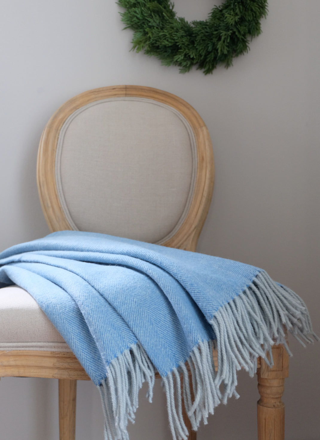 Sininen torkkupeitto Herringbone Blue 100% villaa tuolilla osana olo huoneen sisustusta