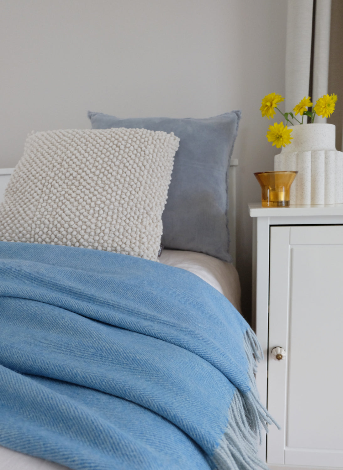 Torkkupeitto Herringbone Blue käytössä – sininen kierrätetty villaviltti sänky sisustus