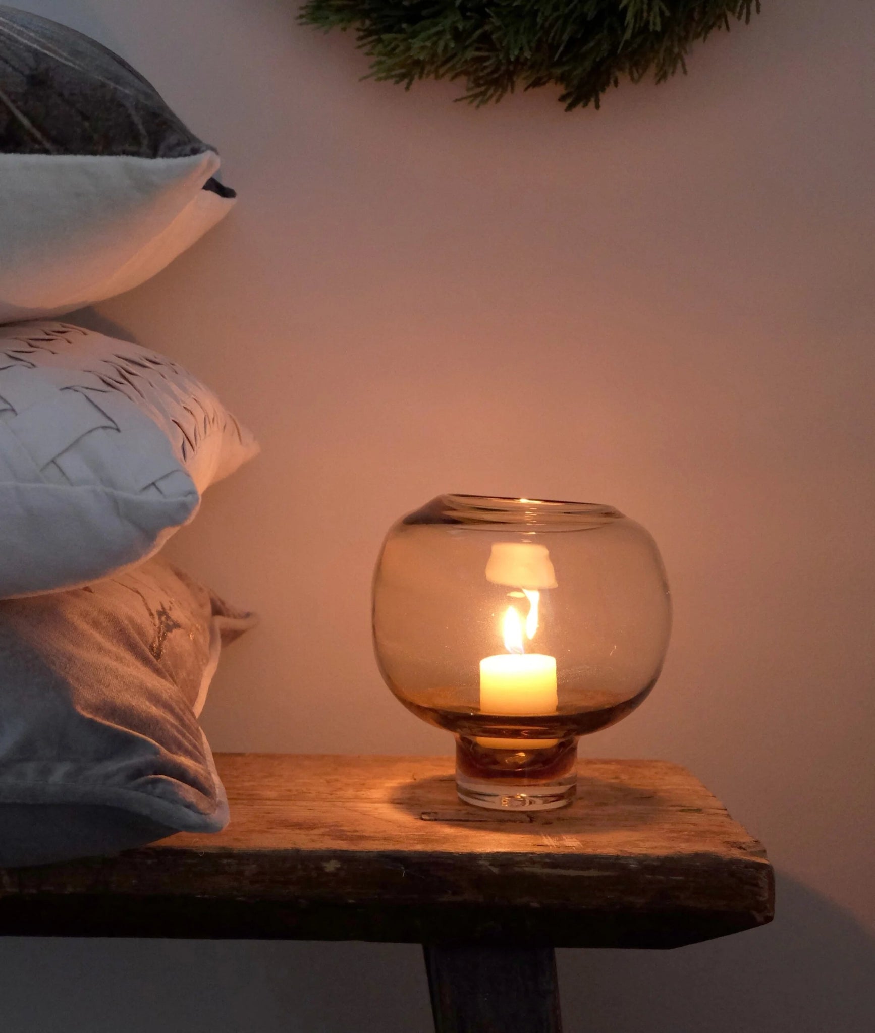 Vaaleanruskea kynttilälyhty sytytettynä – jalallinen lasinen lyhty tunnelmavalaistuksessa