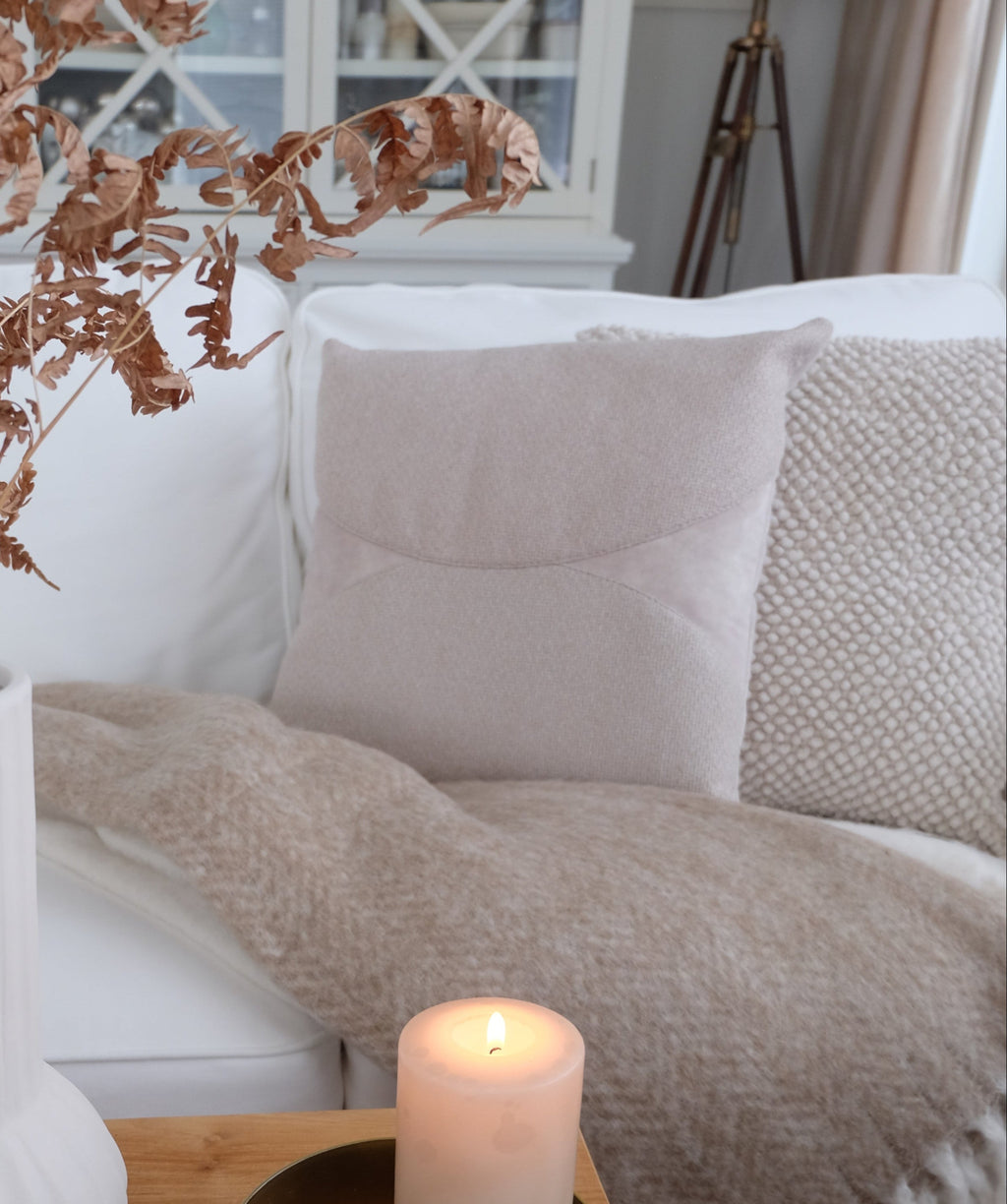 Aria-tyyny sohvalla – beige samettinen koristetyyny olohuoneessa